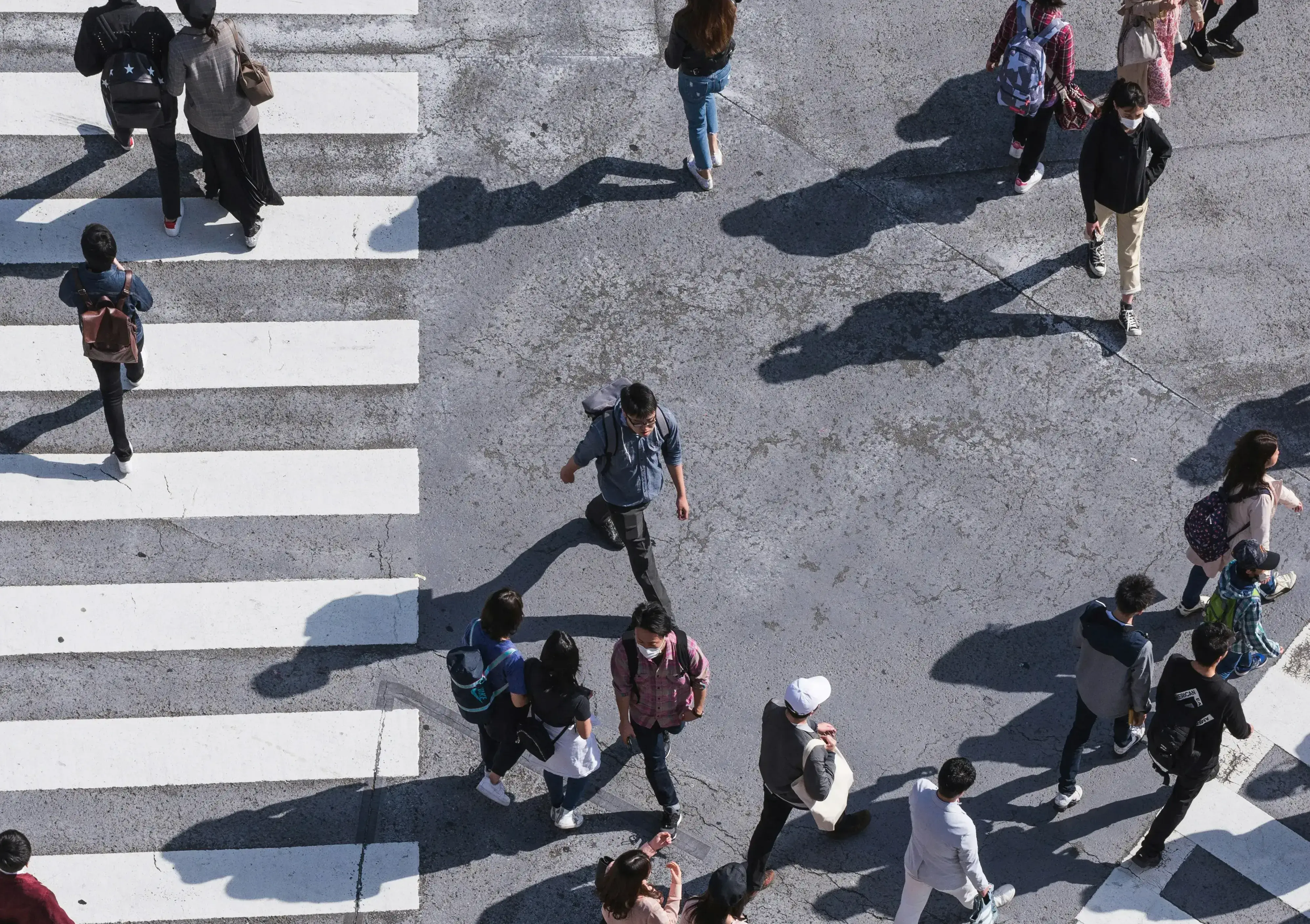 People crossing a city crosswalk — aerial view